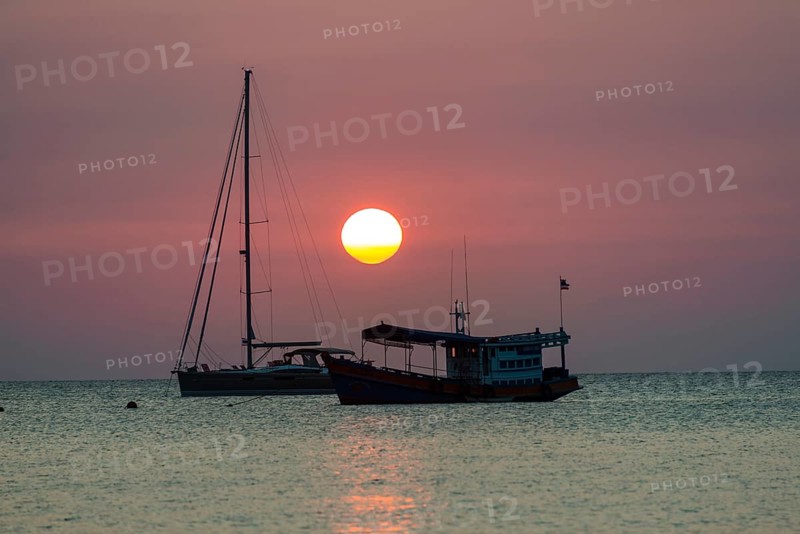 Two boats in sea at sunset
