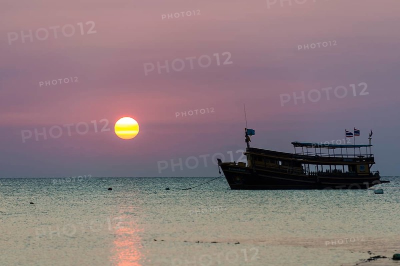 Diving boat in sea at sunset