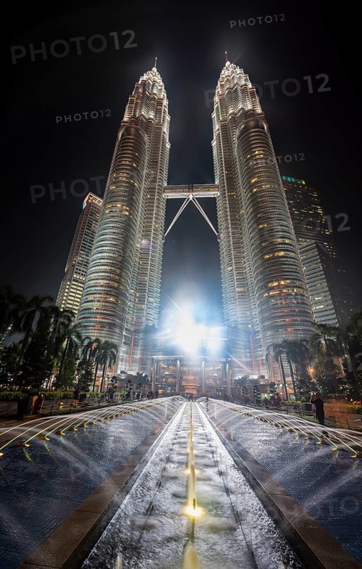 Fountain in front of illuminated Petronas Twin Towers at night