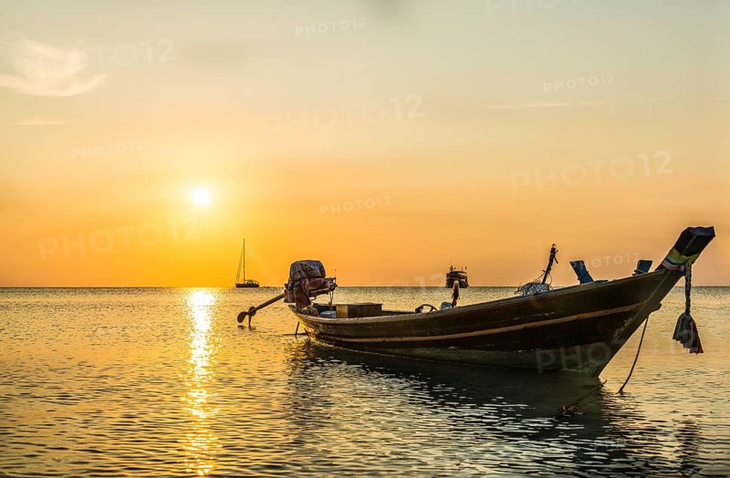Longtail boat in the sea at sunset
