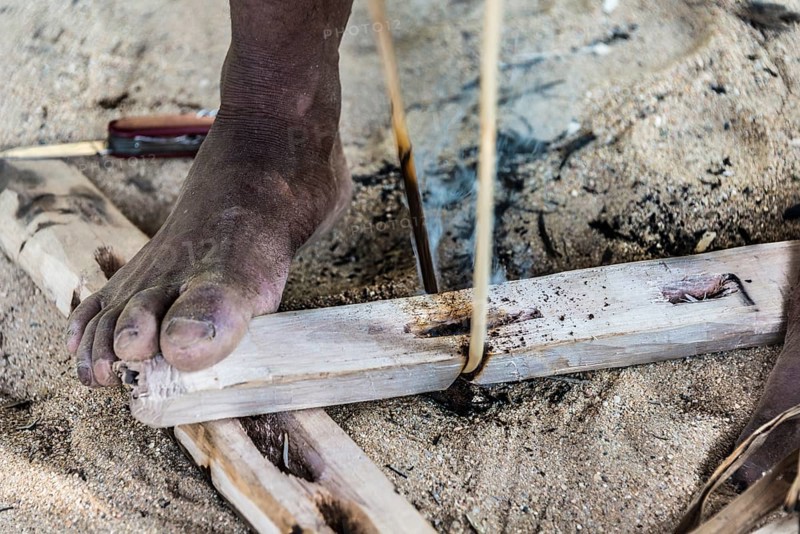 Man of the Orang Asil tribe starting a fire with wood