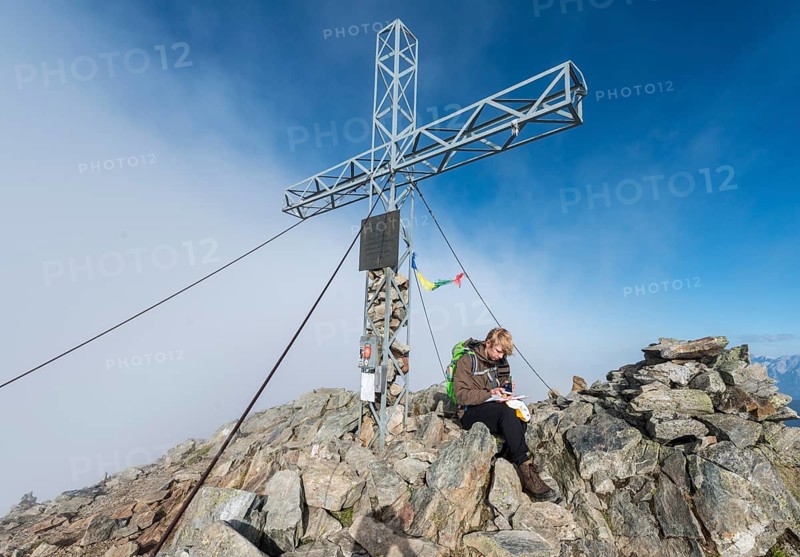 Hiker writing in the logbook at the summit