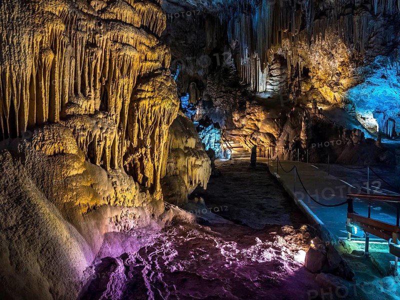 Stalactites in the colorfully lit cave Cuevas de Nerja