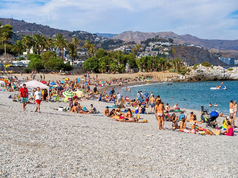 Bathers on the pebble beach of La Herradura
