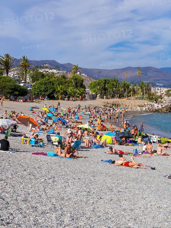 Bathers on the pebble beach of La Herradura