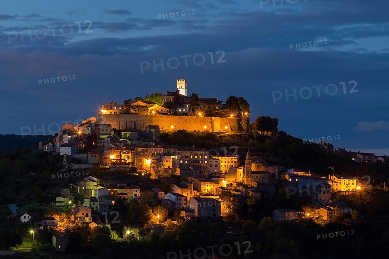 Idyllic village on hilltop with Venetian fortress at night