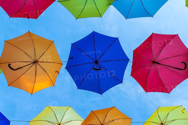 Colourful umbrellas side by side against blue sky