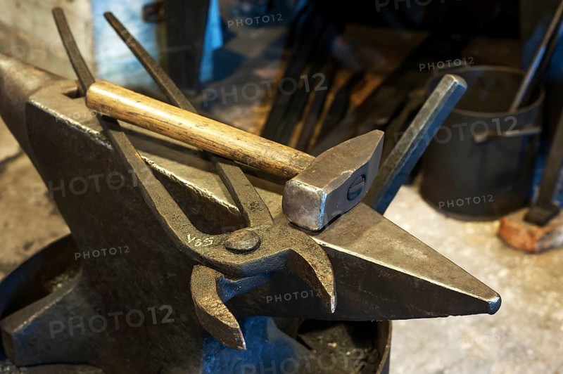 Old blacksmith's anvil with hammer and pincer