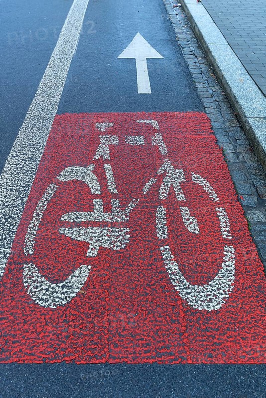 Red marked bicycle path on the roadway