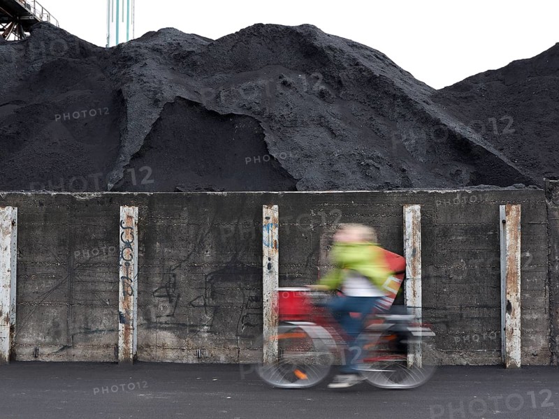 Cyclist riding past coal ash heap