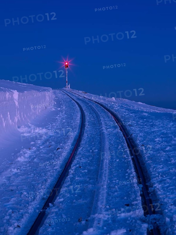 Red signal light on snow-covered tracks of the Brocken railway