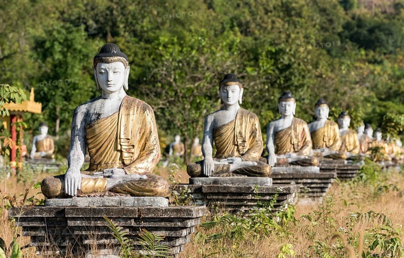Row of Buddha statues in Lumbini Garden under Mt Zwegabin