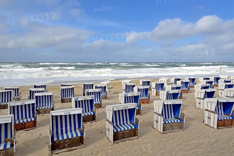 Sandy beach beach of Westerland with white-blue beach chairs at stormy North Sea