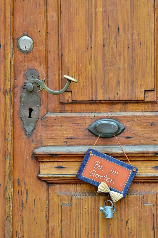Wooden door with sign saying "Bin im Garten"