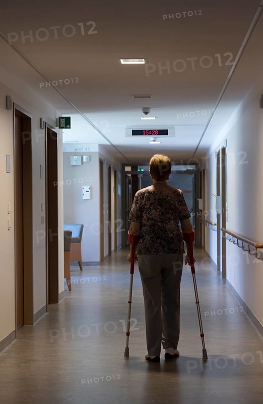 Elderly woman walking with crutches