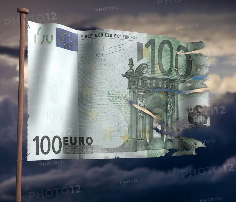 Torn euro flag in front of cloudy sky