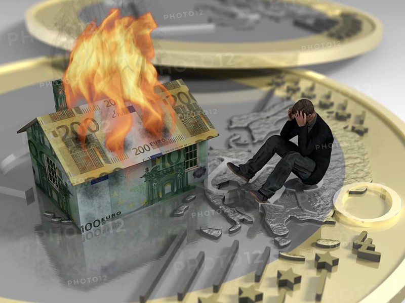 Man sitting on euro next to burning house