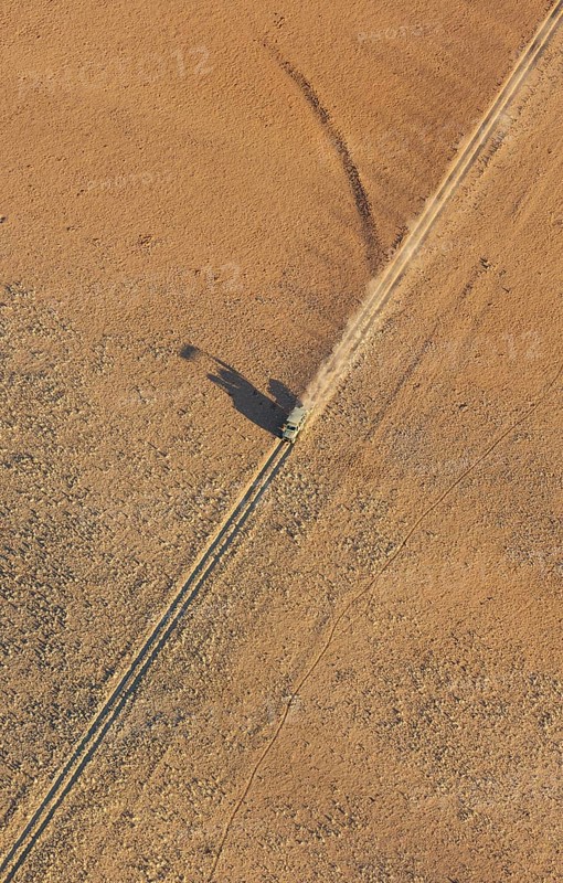 A vehicle of the balloon ground crew crosses a sandy plain
