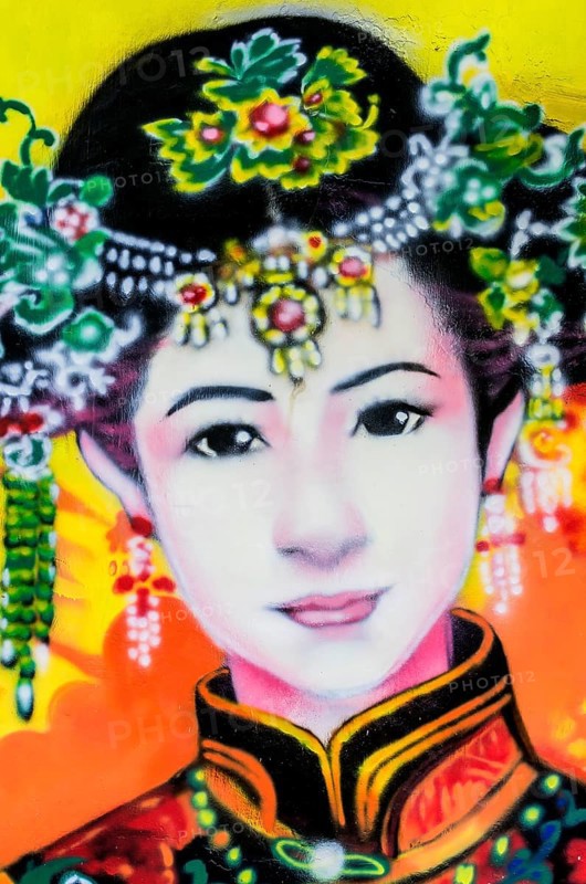 Painted image of a traditionally dressed woman on a house wall