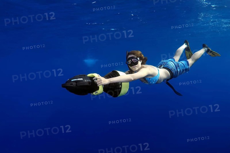 Freediver diving with underwater scooter