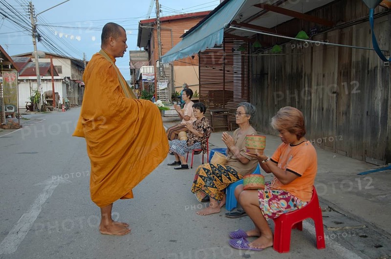 Chiang Khan women offer alms to a monk