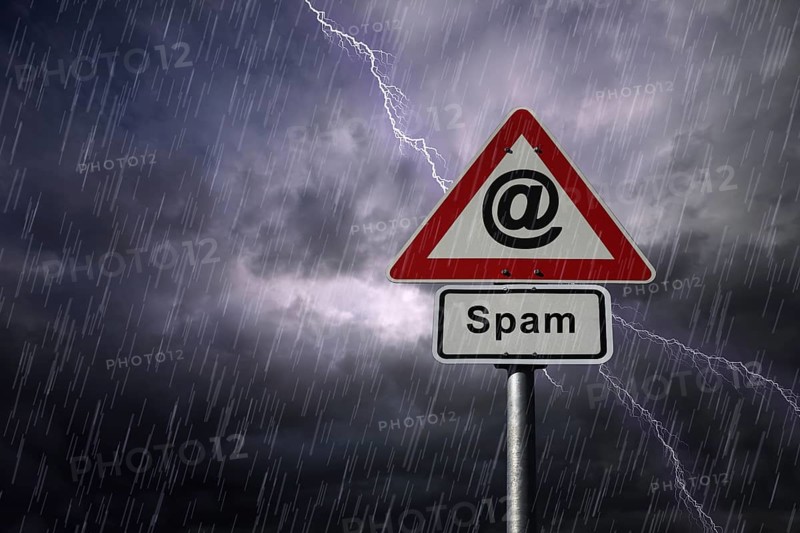 @ symbol and Spam road signs againt a rainy sky with lightning