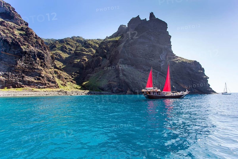 Sailing ship with red sails in a small bay near Los Gigantes