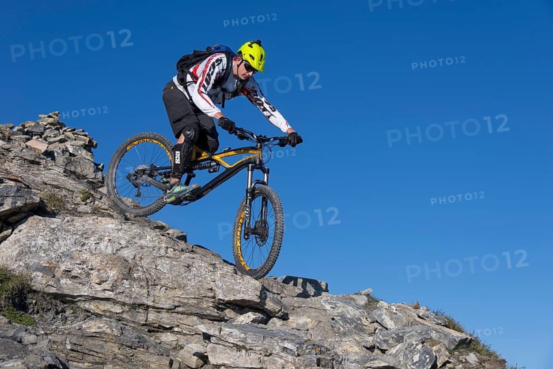 Freeride mountain biker riding over rocks