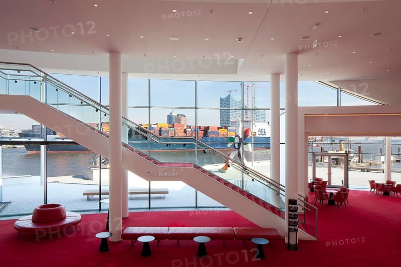 Stairs between the foyer levels overlooking a container ship off the city with the Elbe Philharmonic Hall