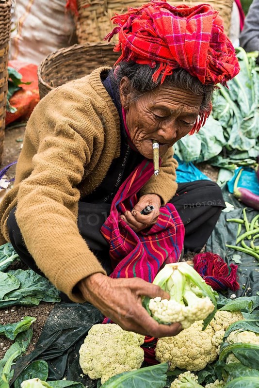 Smoking woman sells vegetables
