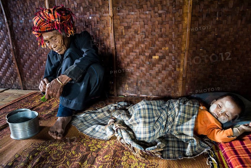 Old woman and sleeping child with thanaka paste in the face of hill tribe Pa-O or Pa-Oh or Pao or Black Karen or Taungthu or dew-soo
