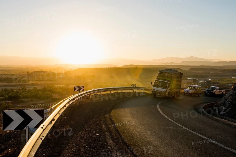 Loaded truck on curvy road in Dades Valley at sunset