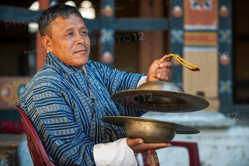 A man with cymbals at a temple festival