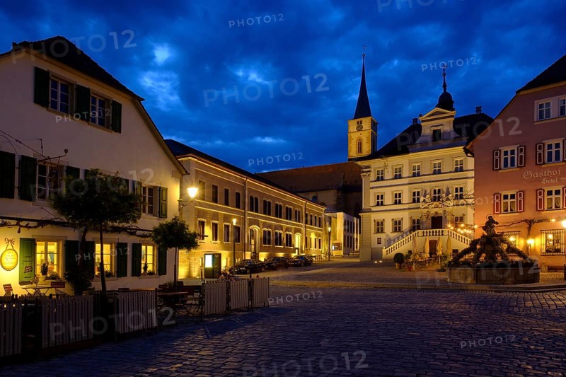 Market place with parish church St. Veit and town hall at dusk