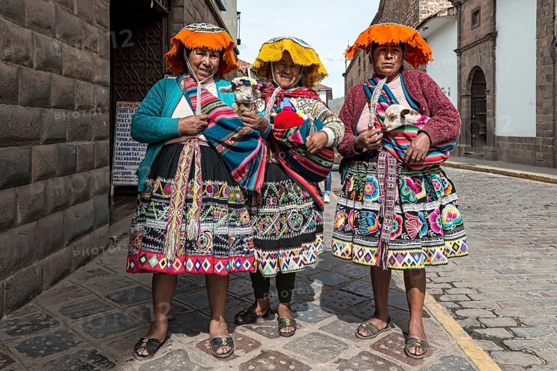 Traditionally dressed women with lambs