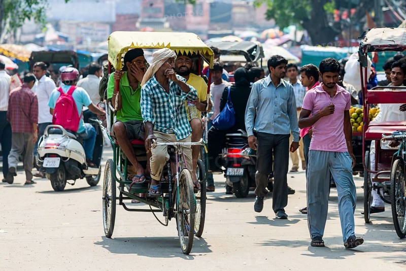 People and cycle rickshaws are moving through the streets of the suburb Old Delhi