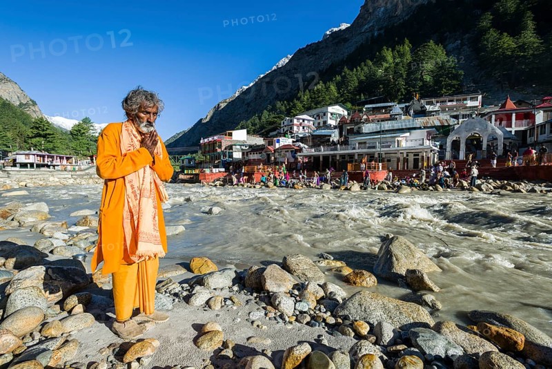 A devotee is praying at the waterfront of the young river Ganges