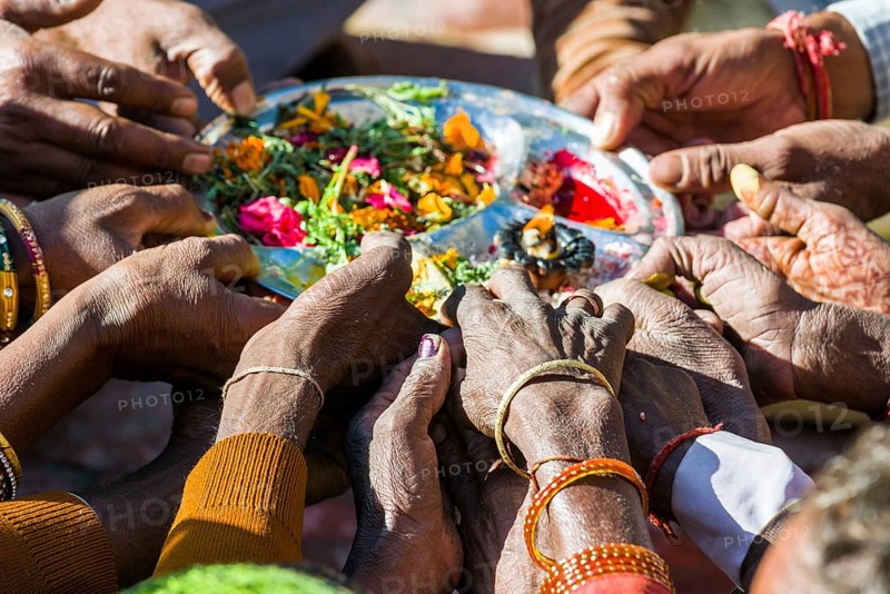 Many hands are holding a plate