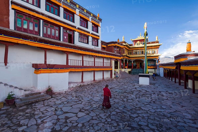 A monk is walking in the inner courtyard of Matho Gompa