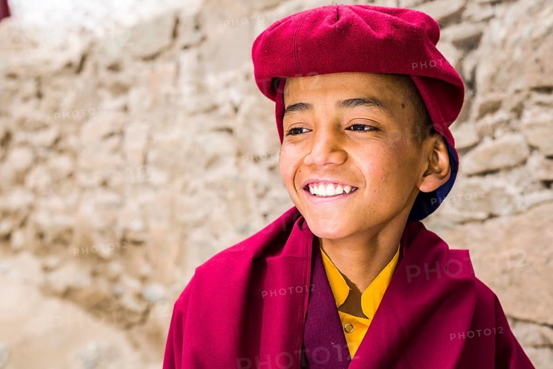 A portrait of a young monk of the Kagyu lineage of Buddhism in red clothes