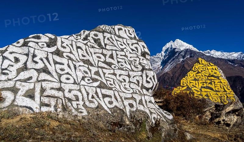 Big Mani stone inscribed with the tibetan mantra Om mani padme hum in the background mountain Kangtega