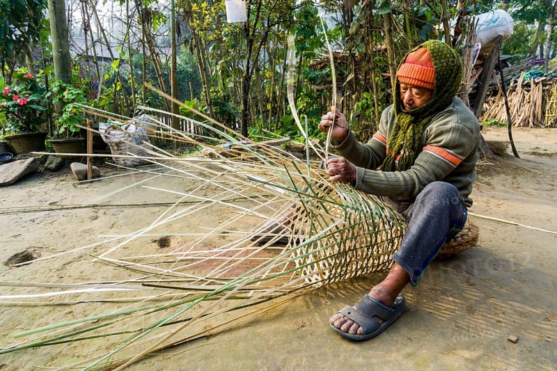A man is weaving a bamboo basket