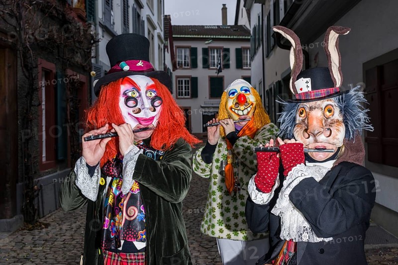 Many different groups of masked people walking through the streets of Basel