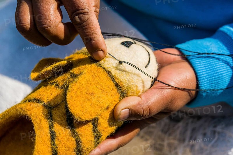 Hands of a woman working on felt shoes