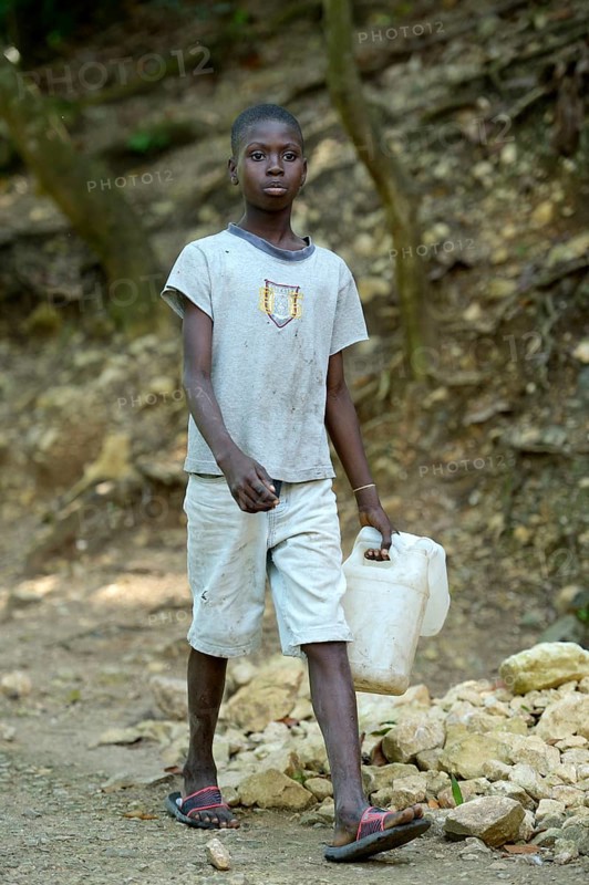Boy with empty cans to fetch water
