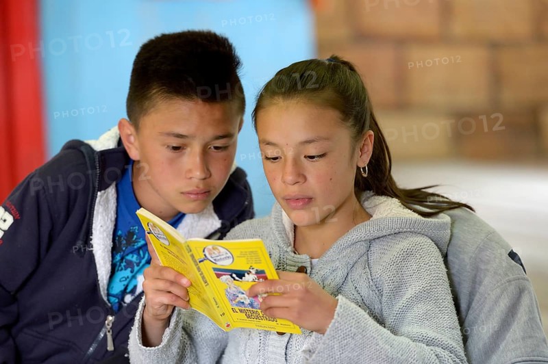 Girl and boy reading a book together