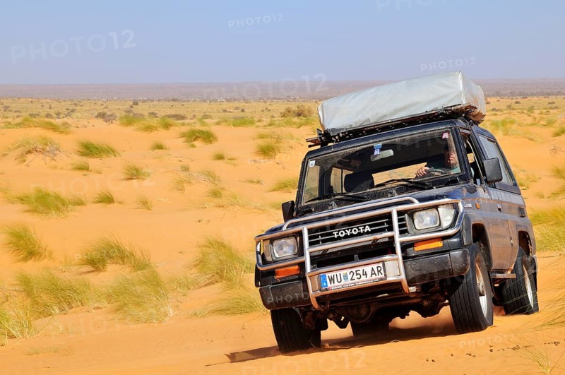 SUV with roof tent on the road in the desert