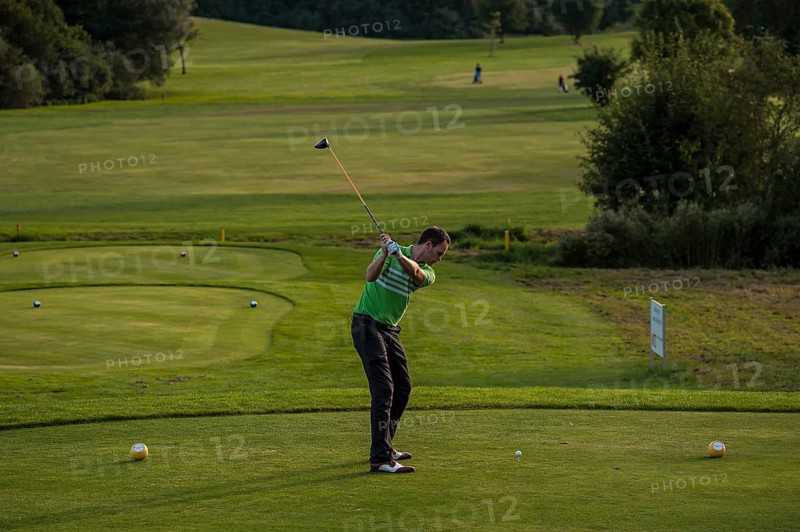Golfer striking the ball on a golf course