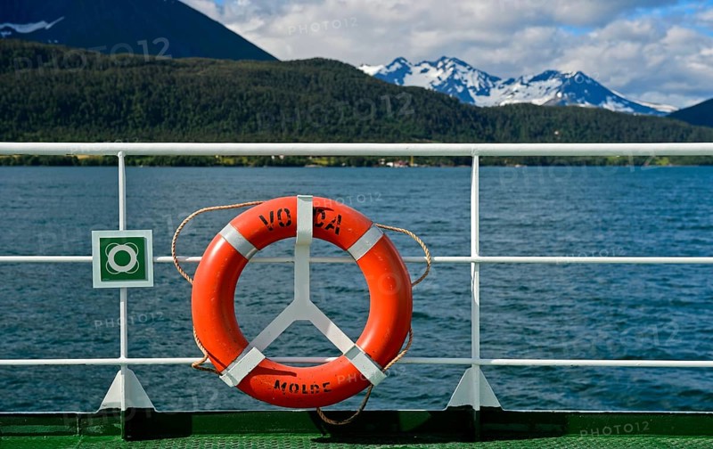 Lifebuoy on ferry Volda in front of a fjord landscape