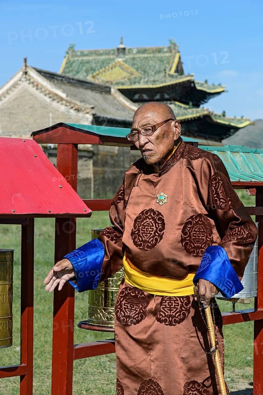 Old man in traditional Mongolian costume with Buddhist prayer beads in left hand